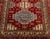 Indian Kazak Style Wool Carpet, with geometric design on a red ground, label to underside. 9' 7" L x 6' W. Provenance:...