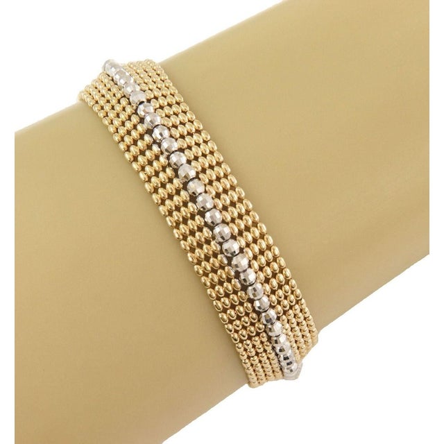 This Wide Beaded Mesh 14k Two Tone Gold Bracelet is a stunning piece of fine jewelry that features a unique chain style...