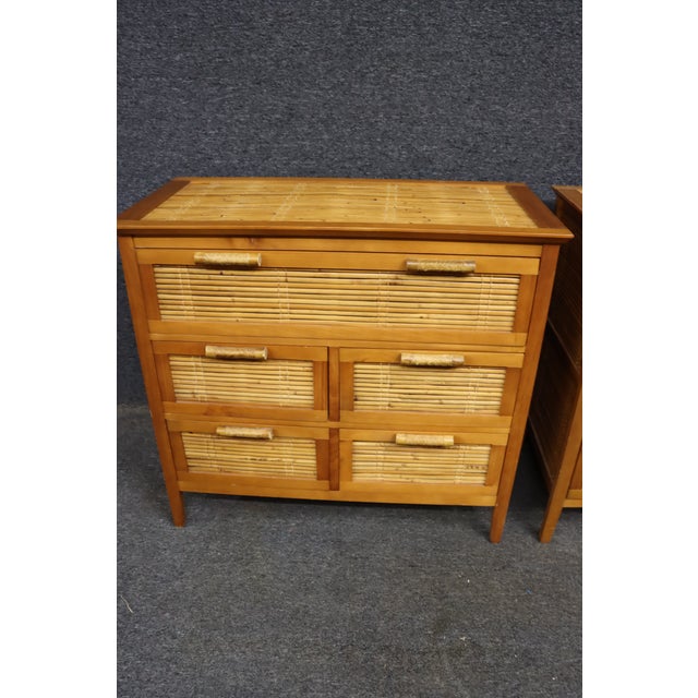 Pair of Asian-style chests crafted with cherry-toned wood frames and woven bamboo panels. Each chest features five...