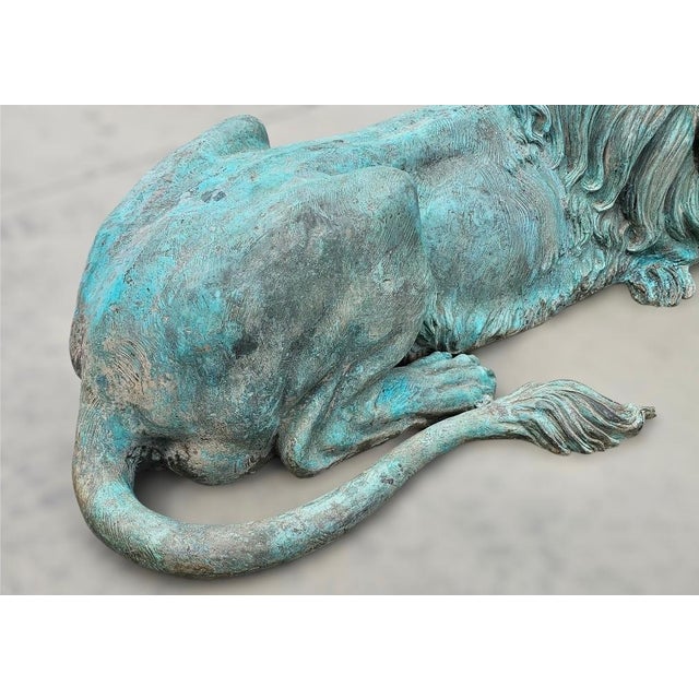 A pair of signed bronze lion statues in a lying down position but alert. The verdigris patina finish is excellent on this...