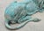 A pair of signed bronze lion statues in a lying down position but alert. The verdigris patina finish is excellent on this...