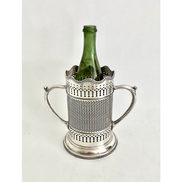 This beautiful English silver wine holder has intricate open weave sides and detailed fretwork along with dramatic double...