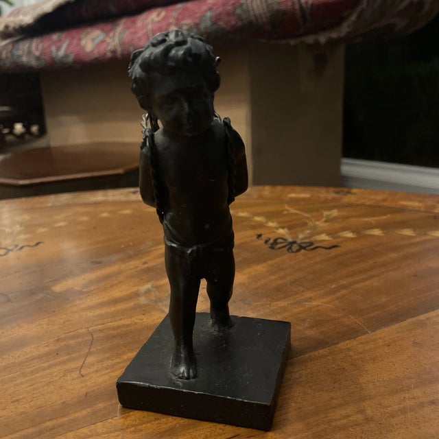 Vintage 7" cast bronze figural statue is a delightful cherub boy carrying a basket on his back. The basket appears to be...