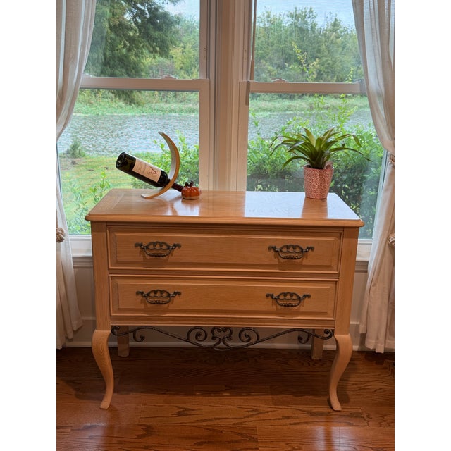 Warm wood tones, graceful curves, and decorative ironwork give this Thomasville console a welcoming presence with...