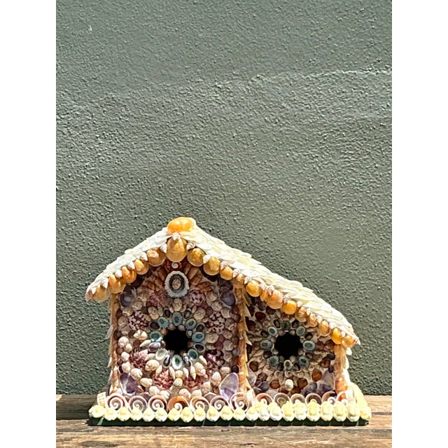 This charming vintage birdhouse is a stunning example of coastal folk art, meticulously encrusted with a diverse array of...