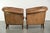 This sturdy set of 2 large vintage sheepskin club armchairs features a beautiful patina. The armchairs have loose seat...
