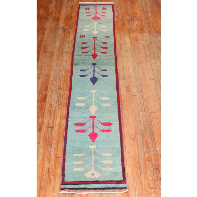 A lovely turkish runner from the middle of the 20th century with a floral motif on a teal ground Measures: 1'11''x 11'4''.
