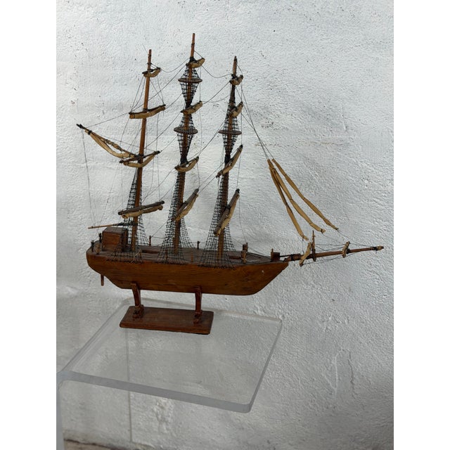 This is a wonderful vintage handmade model of a three-masted sailing ship, intricately constructed in wood with an...