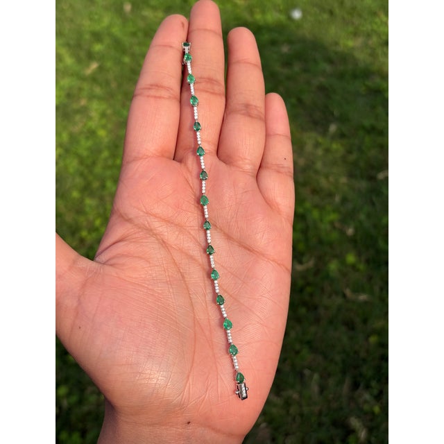 This tennis bracelet features 2.44 carats of pear‑shaped natural emeralds set in 14K white gold. Each emerald measures...