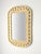 A vintage Polynesian-inspired faux rattan wall mirror, marked 1979. The mirror's unique style is defined by its molded...