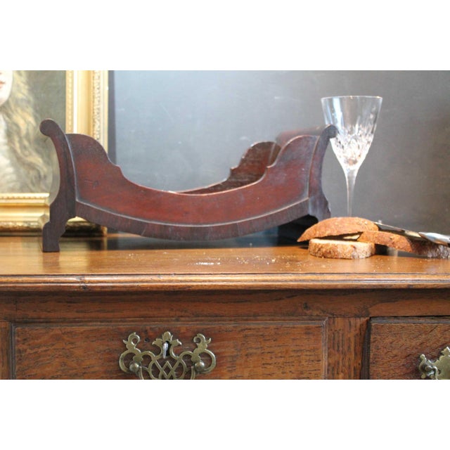 A fine Georgian Mahogany cheese coaster or cradle which features a slated bateau design and would accommodate a sizeable...