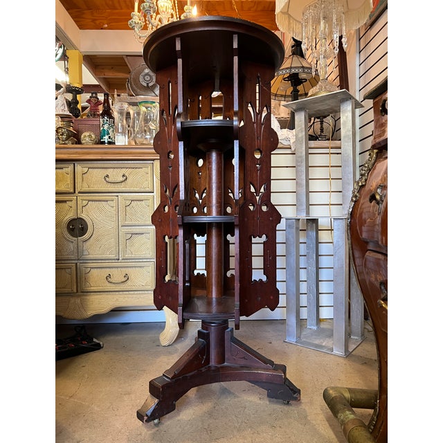 This is a unique piece. Hand carved Dark wood revolving shelf on whells. featuring intricate fretwork and design. It has 3...