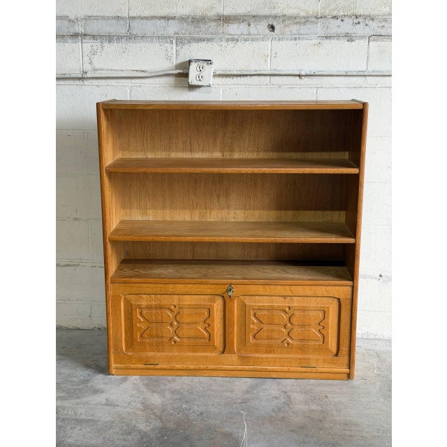 This oak shelving unit combines open upper bookshelves with a functional drop-front desk compartment below. The lower...