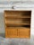 This oak shelving unit combines open upper bookshelves with a functional drop-front desk compartment below. The lower...