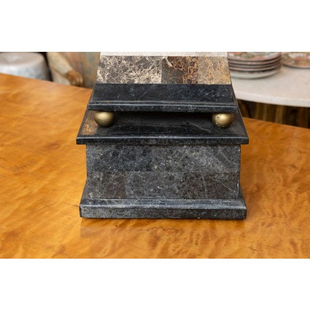 This is a striking decorative obelisk handcrafted from alternating bands of richly colored natural marble, showcasing a...