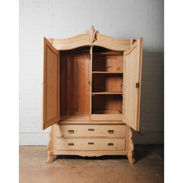 This hand-crafted armoire is constructed entirely from solid pine and showcases a beautifully scrolled pediment with...