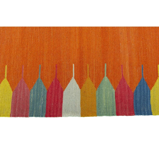 This small handwoven kilim from the Fars region impresses with its cheerful, colorful design. The vibrant orange in the...