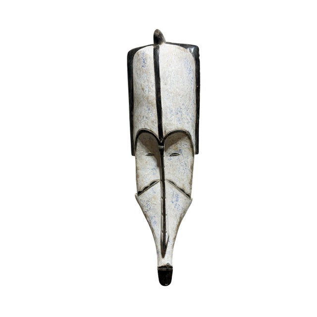 Superb vintage Fang mask carved from a single piece of heavy wood, featuring an elongated heart-shaped face rendered in...
