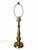 A tall, slender baluster table lamp with a warm brass-tone finish and delicate etched decoration on its stem and urn-...