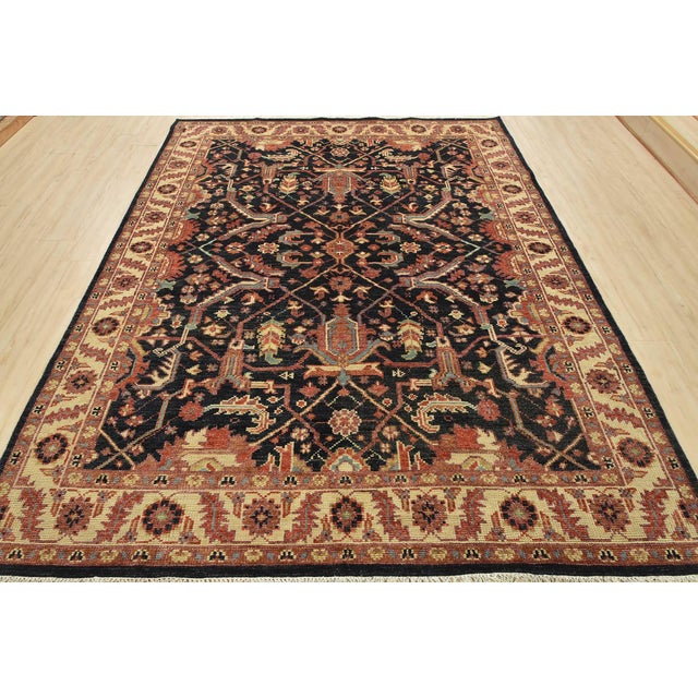 A traditional Heriz rug hand-knotted with an all-wool pile on a cotton foundation. This oriental rug features an all-over...