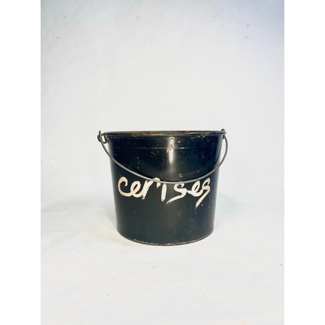 Vintage metal pail featuring original black finish with hand-painted French "cerises" (cherries) lettering. Sturdy metal...