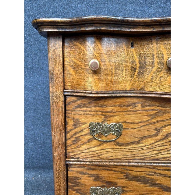 This is a beautiful vintage chest of drawers. It features an elegant, curved serpentine bow-front silhouette, a hallmark...