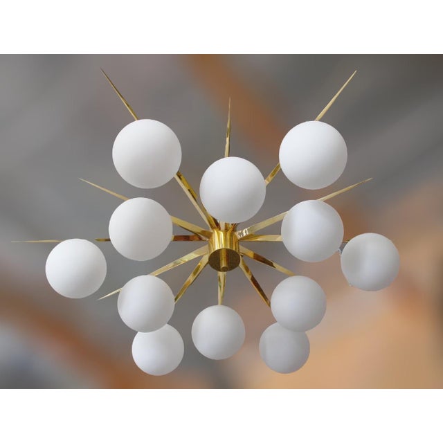 Italian midcentury flush mount with 12 large matte white Murano glass globes mounted on solid brass frame in lacquered...