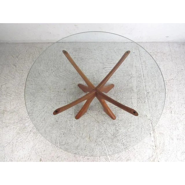This sculpted jacks style coffee table features unique mid-century design with a wonderful natural finish. Thick glass top...