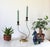 Mid-century black metal and brass scrolled double-candle holder features asymmetric curved stems and a circular brass-...