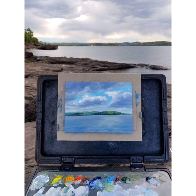 This oil painting captures a serene view of Presque Isle, showcasing a tranquil lake scene under a dynamic sky filled with...