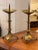 A pair of brass altar pricket sticks with tall, tapering columns and petal-shaped tripod bases. The drip pans feature...