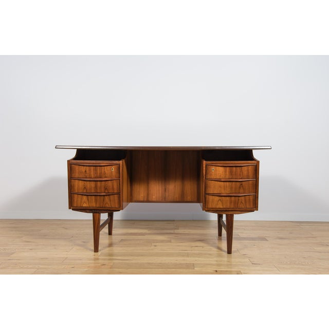 This freestanding desk was manufactured in Denmark in the 1960s. The piece is crafted from rosewood. The desk features...