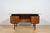 This freestanding desk was manufactured in Denmark in the 1960s. The piece is crafted from rosewood. The desk features...
