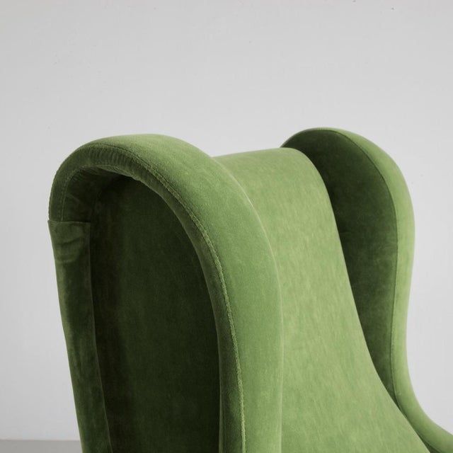 An early original 'Senior' lounge chair, upholstered in new green English velvet. Metal frame with brass leg fittings and...