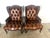Pair of leather tufted wingback armchairs. The chairs are upholstered in a rich brown tufted leather with nailhead trim...