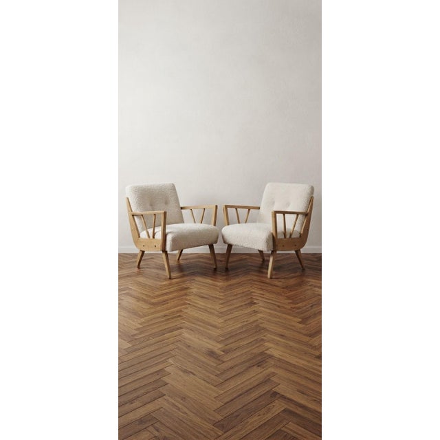 A rare and collectible matching pair of fully refurbished mid-century modern lounge armchairs designed by renowned...