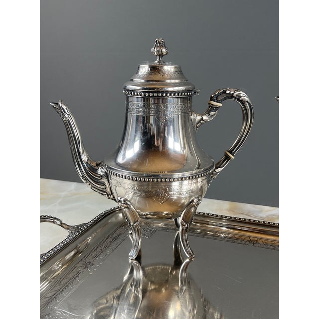 An elegant silver-plated tea and coffee service comprising two teapots/coffee pots, a covered sugar bowl, a milk jug, and...