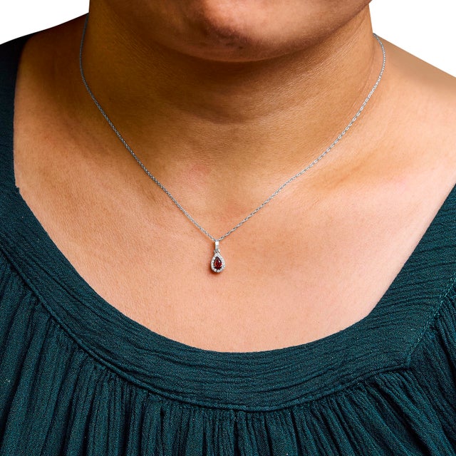Drape elegance around your neck with this enchanting 10K white gold pendant necklace, where a luscious pear-shaped red...