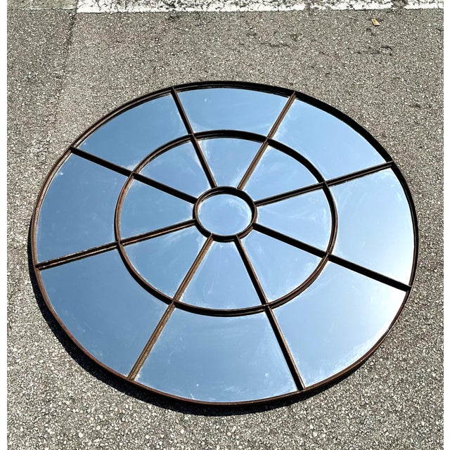 This vintage round wrought iron windowpane mirror is a striking example of industrial-era design, combining architectural...