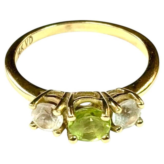 Charming 14K Gold, Peridot and Cubic Zirconia Cocktail Ring. Ring features a vivid green peridot flanked by two colorless...