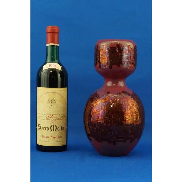 A stunning double-bulb vase in glazed and vitrified ceramic, entirely hand-crafted on a wheel, glazed with gold and ruby...