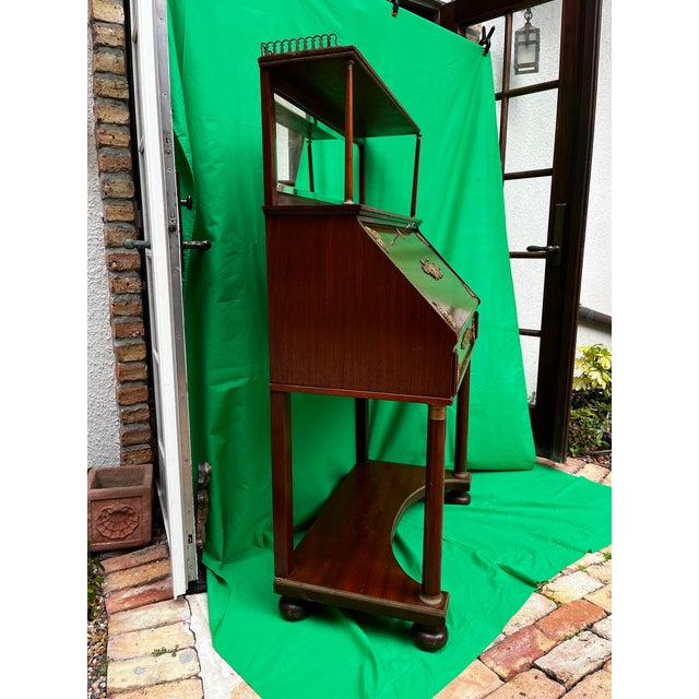 This lovely solid mahogany French Empire style secretary features a dainty display cabinet above the body of the flip down...