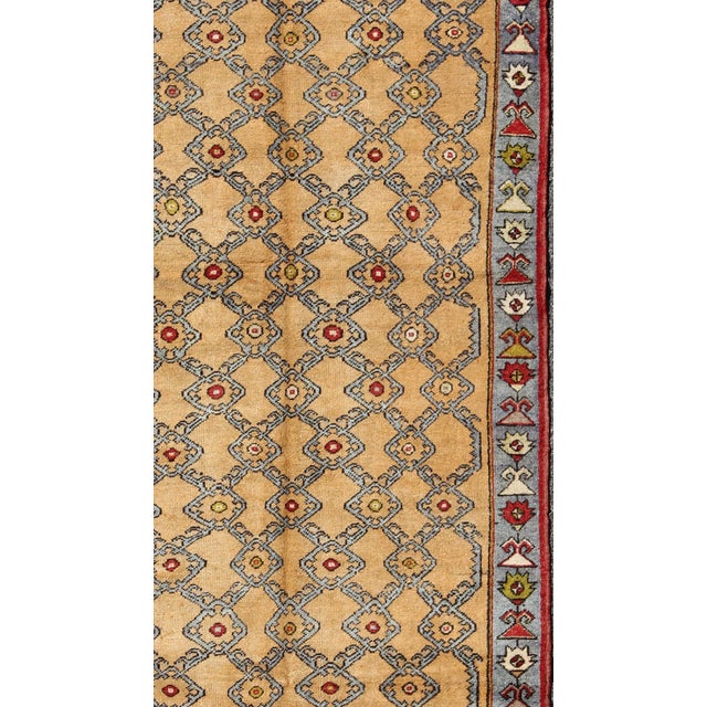 Measures: 5 x 11'5. Vintage Turkish Oushak Rug with Golden Tan Field and Repeating Rosette Motif. Keivan Woven Arts /...