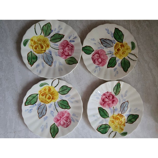 Charming vintage hand-painted ceramic tea set featuring cheerful floral motifs in soft yellow, pink, green, and blue. The...