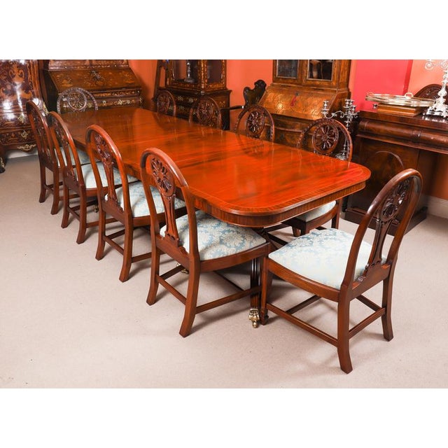 This is a fabulous high quality vintage flame mahogany Regency revival twin pillar dining table that can seat 10 people in...