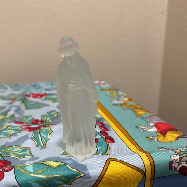 Crafted with a smooth, matte "satin glass" finish, the figure stands approximately 4 inches tall and features delicate...