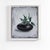 About the painting: this striking artwork showcases a luscious green plant elegantly emerging from a glossy, dark, oval...