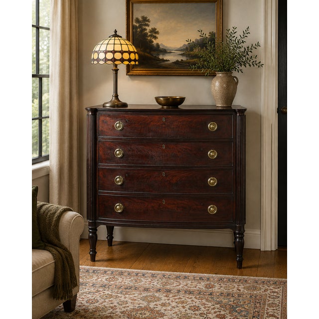 A handsome New England Federal mahogany bow-front chest of drawers dating to circa 1810–1825, with the restrained elegance...