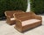 A striking pair of vintage woven rattan lounge sofas featuring dramatic curved silhouettes and oversized braided trim....