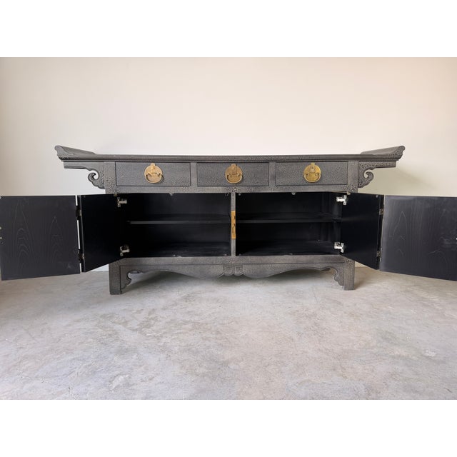 A stunning Baker Furniture sideboard inspired by classic Ming-style design, featuring an elegant black crackle finish...
